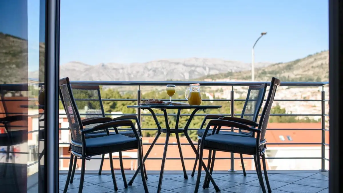 Terrace of an apartment at California Apartments with a table, two chairs and a view of the mountain
